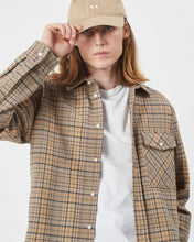 Load image into Gallery viewer, the Minimum Men&#39;s Woad Overshirt in Brown Sugar on a model posing with his hand on the brim of his hat
