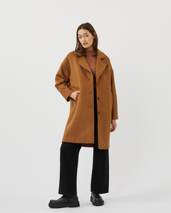 model posing wearing the Minimum Women's Gutha Jacket in Roasted Pecan over wide leg black pants with black combat boots
