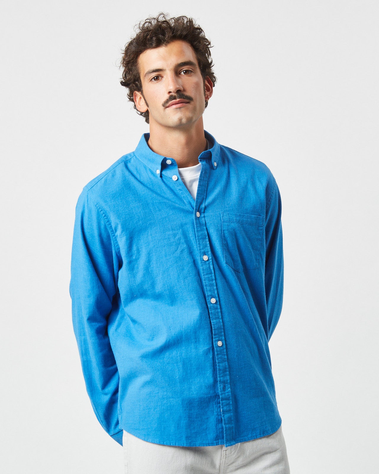 the Minimum Men's Jay Shirt in French Blue on a model posing with his hands behind his back