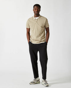 the Minimum Men's Zane Polo in Seneca Rock on a model standing with his hands in his pockets