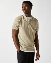 Load image into Gallery viewer, the Minimum Men&#39;s Zane Polo in Seneca Rock on a model posing with one hand in his pocket looking over his shoulder
