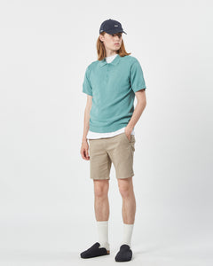 the Minimum Men's Cavli Polo in Oil Blue on a model posing with his hand in his pocket
