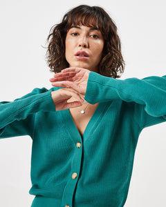 close up of the Minimum Women's Cardine Cardigan in Bayou on a model posing with her hands in front of her face