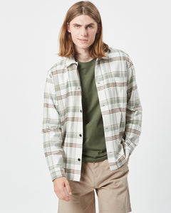 Minimum Men's Kaase Overshirt in Oil Blue on a model posing with one hand in his pocket looking at the camera with a smirk
