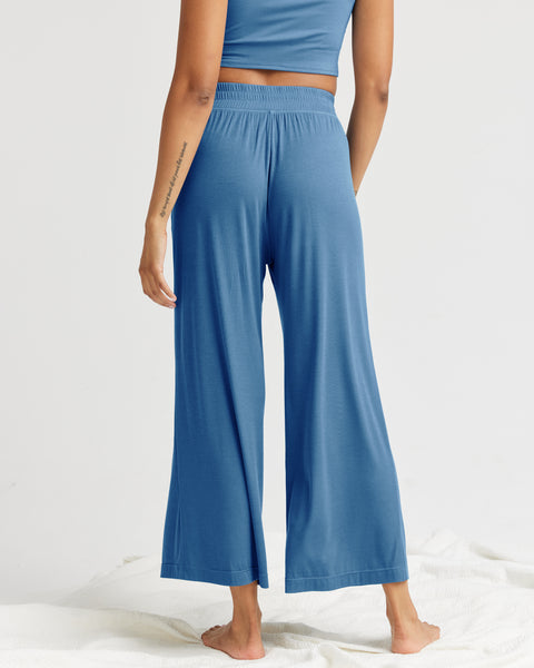back view of a model wearing the Richer Poorer Women's Night Knit Pant in Blue Horizon standing against a white background