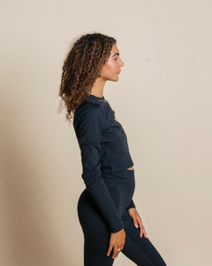 side view of a model wearing the Girlfriend Collective ReSet Long Sleeve Tee in Black