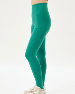 side view of a model wearing green leggings