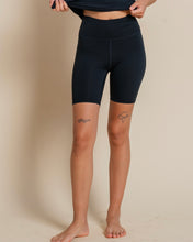 Load image into Gallery viewer, close up of the front of the Girlfriend Collective ReSet Bike Short in Black on a model
