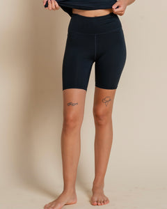 close up of the front of the Girlfriend Collective ReSet Bike Short in Black on a model
