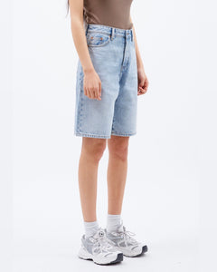 the Dr. Denim Women's Bella Shorts in Bleach Sky on a model standing on an angle