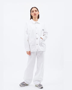 the Dr. Denim Women's Ina Jacket in White on a model wearing the matching pant posing with her hand in the jacket pocket
