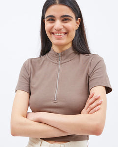 model smiling into the camera with her arms crossed wearing the Dr. Denim Women's Nina Zip Tee in Walnut