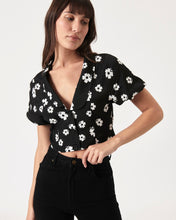 Load image into Gallery viewer, the Rolla&#39;s Folk Floral Susie Top in Black worn by a model posing with her hand on her waistband
