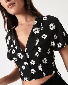 a close up of the front angled view of the Rolla's Folk Floral Susie Top in Black on a model
