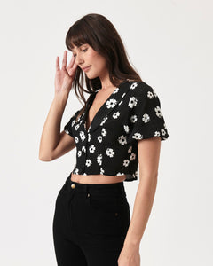 the Rolla's Folk Floral Susie Top in Black worn by a model posing to the side with her hand near her ear