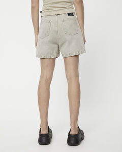 the back view Afends Women's Seventy Threes Denim Shorts in Faded Cement on a model