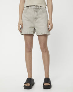 the Afends Women's Seventy Threes Denim Shorts in Faded Cement on a model