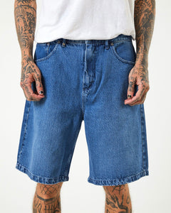 close up of the front view of the Afends Men's Lil C Denim Short in Authentic Blue on a model