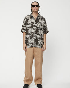 the Afends Men's Short Sleeve Jungle Shirt in Earth Camo on a model
