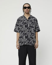 Load image into Gallery viewer, the Afends Men&#39;s Script Short Sleeve Cuban Shirt in Black Camo on a model standing
