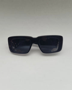 the Spitfire Cut Seventy Sunglasses in black laying on a neutral background