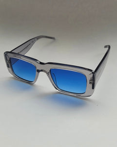 the Spitfire Cut Seventy Sunglasses in clear with blue lens sitting at an angle against a neutral background