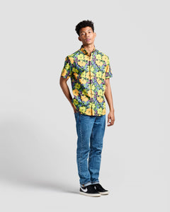 the Poplin & Co Men's Short Sleeve Printed Shirt in Tropical Floral paired with jeans worn by a model standing against a neutral background with one hand in his back pocket
