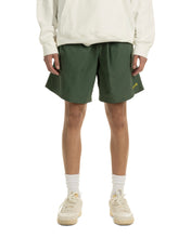 Load image into Gallery viewer, the front view of the Taikan Nylon Shorts in Forest Green laying worn by a model
