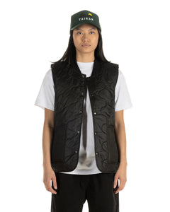 the Taikan Quilted Vest in Black worn by a model open over a tee 