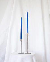 Load image into Gallery viewer, a pair of Socco Designs Taper Candles in bright blue in two tapers of varying heights against a white sheet background
