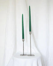 Load image into Gallery viewer, a pair of Socco Designs Taper Candles in green in two tapers of varying heights against a white sheet background
