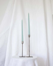 Load image into Gallery viewer, a pair of Socco Designs Taper Candles in light blue in two tapers of varying heights against a white sheet background
