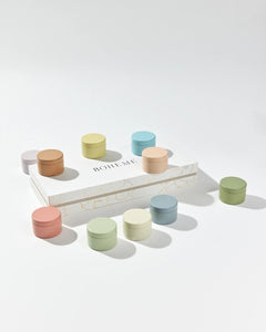 Boheme Fragrances Wanderlust Discovery Candle Set box laying flat with lidded multi coloured candle pots scattered around