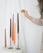 Load image into Gallery viewer, five Socco Designs Taper Candles in varying stands, one is being lit with a match by a hand entering the frame from the right
